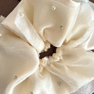 Close-up of cream mesh scrunchie with layered organza fabric and decorative faux pearls