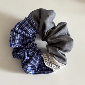 Detailed macro view of blue plaid fabric and grey twill stitching with white lace trim