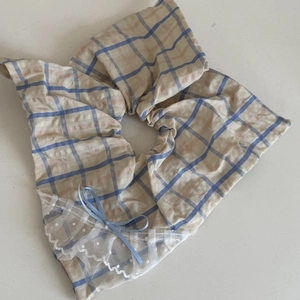 Détail d'un accessoire cheveux à carreaux avec dentelle, nœud bleu et bords à pois