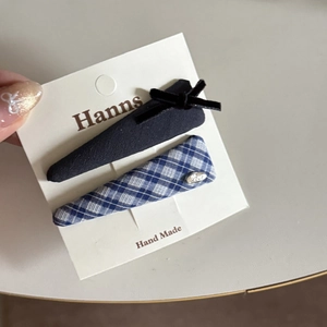 Detailed view of handmade black velvet and blue checkered hair clip set on display card