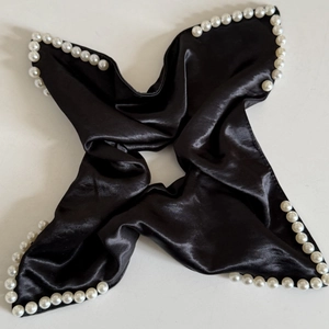 Elegant black satin hair scrunchie with white pearl beads on white background