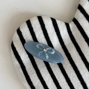 Pince à cheveux ovale bleu-gris avec nœud iridescent et cristal sur base en peluche