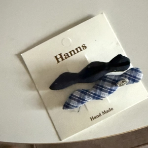 Detail of blue plaid and black fabric hair clips with metal buckle on display card