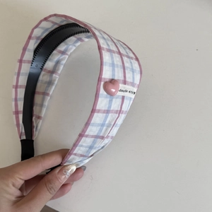 Détail d'un serre-tête en tissu écossais avec breloque cœur et étiquette fait main