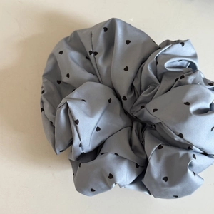 Scrunchie in raso azzurro con cuori neri e volume plissettato dal design elegante