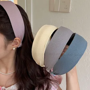 Détail de bandeaux plissés en tissu aux tons pastel montrant une texture rayée chic
