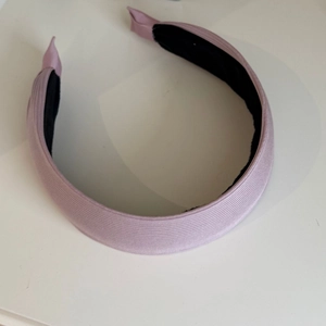 Détail du serre-tête en tissu rose pâle nervuré avec texture douce et doublure antidérapante