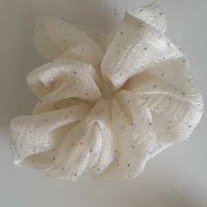 Detail of cream chiffon scrunchie featuring delicate silver beads and textured mesh fabric