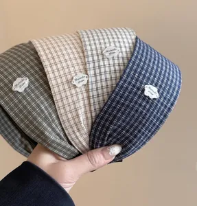 Detail view of plaid fabric headbands with cute white cloud charms in four colors