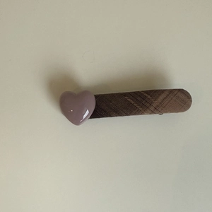 Pince à cheveux à carreaux marron avec détail de cœur violet 3D sur fond beige uni