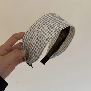 Detail of checkered wide headband featuring a cloud tag and soft fabric wrap on ends