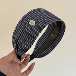Detail showing blue plaid fabric headband with cloud decor and non-slip inner teeth