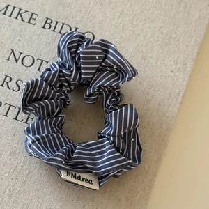 Chouchou en tissu à rayures bleues avec paillettes scintillantes sur fond en toile