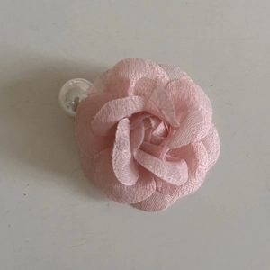 Detail view of light pink mesh camellia flower hair clip with layered petals and center