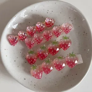 Détail de barrettes fraises en acétate rouge et rose scintillant sur une assiette blanche