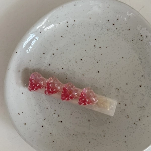Barrette à cheveux fraise mignonne en acétate avec motif pailleté sur plateau blanc