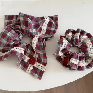 Macro shot of plaid hair scrunchie set with red heart buttons and lace trimmings