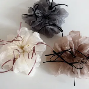 Three ballet-style organza ribbon bow scrunchies in neutral colors on a white background