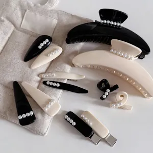 Détail de pinces à cheveux en acrylique noir et blanc avec perles élégantes