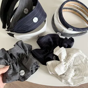 Close-up of striped fabric headbands and scrunchies featuring a Paris logo button detail
