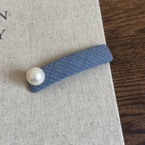 Minimalist denim fabric hair clip with a single white pearl accent for daily styling