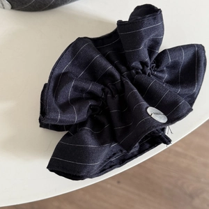 Navy blue striped scrunchie with white pinstripes and a decorative Paris button detail