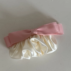 Pink ribbon bow on cream satin ruffled hair clip with vintage aesthetic design