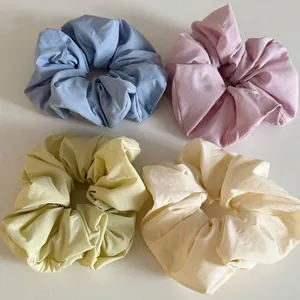 Set of four fluffy solid color oversized scrunchies in blue pink yellow and white