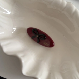 Detail of dark red acetate hair clip with black bow and France Handmade gold logo