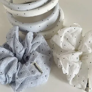 Close-up of blue and white polka dot scrunchies and padded headbands with textured fabric
