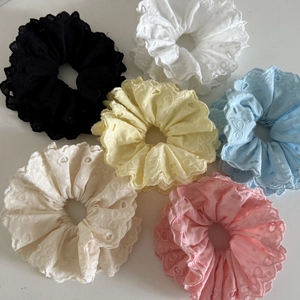 Flat lay of six colorful ballet style lace scrunchies with heart embroidery
