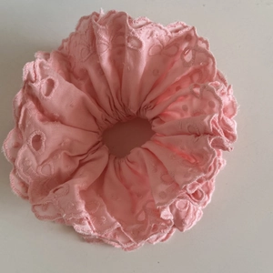 Detail of light pink ballet-style lace scrunchie with embroidered floral patterns