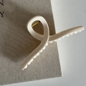 Detail view of the elegant cream blue twisted claw clip with a golden metal spring