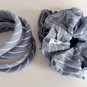 Detail of blue striped scrunchie and headband set with minimalist woven label