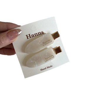 Set of two elegant white marble acetate hair clips with golden accents for women
