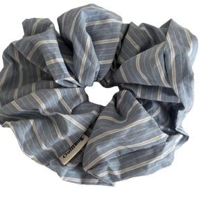 Minimalist blue striped fabric scrunchie with white brand label in college style