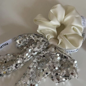 Elegant off-white satin bow scrunchie with silver sequins and stylish ribbon detail