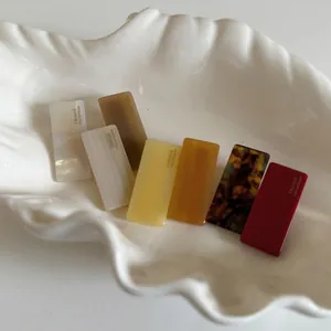 French style acetate hair clips in seven assorted colors on a shell tray