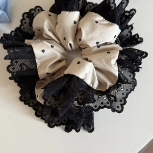 Elegante elastico beige con motivo a cuori, pizzo nero e consistenza setosa