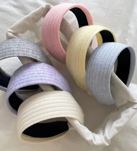 Detailaufnahme von sechs bunten, breit gerippten Stoffhaarbändern in sanften Pastelltönen