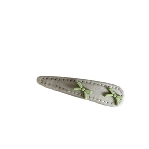 Sweet light grey BB hair clip with two green bows and white stitching on a white background