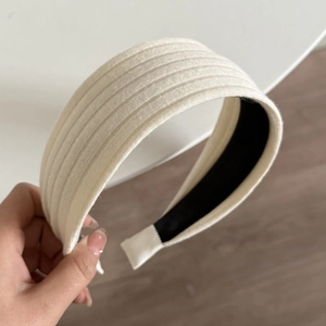 Nahaufnahme des cremeweißen gestrickten Stirnbands mit Rippenstruktur und Anti-Rutsch-Futter