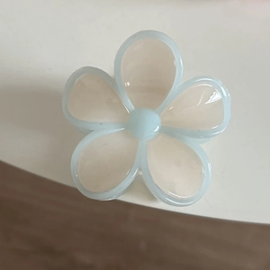 Detailed macro view of a translucent light blue jelly five-petal flower hair clip