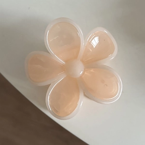 Detail of peach flower claw clip with semi-transparent petals and glossy resin finish
