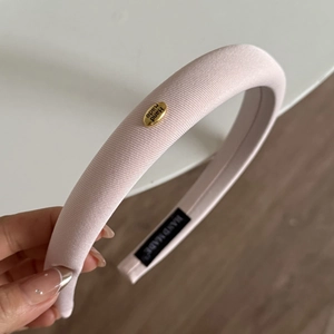 Serre-tête en éponge rose avec texture côtelée et plaque en métal doré