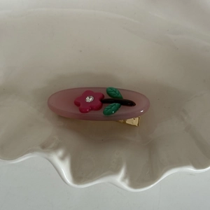 Rosa Strass-Blumen Haarspange mit Jelly-Effekt auf weißem dekorativem Teller