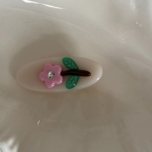 Nahaufnahme der süßen ovalen Haarklammer in Gelee-Farben mit rosa 3D-Blüte