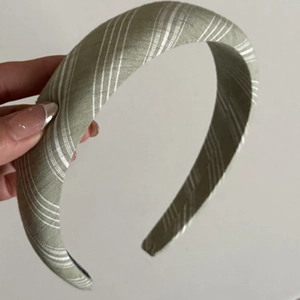 Détail d'un serre-tête épais en tissu de lin à rayures vert sauge et blanc élégant