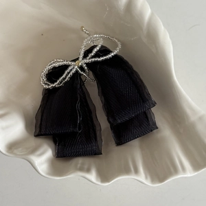Detailed macro view of the black mesh bow hair clip with silver beaded center