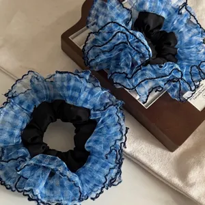 Blue plaid mesh scrunchie with black lace trim on rustic wooden display